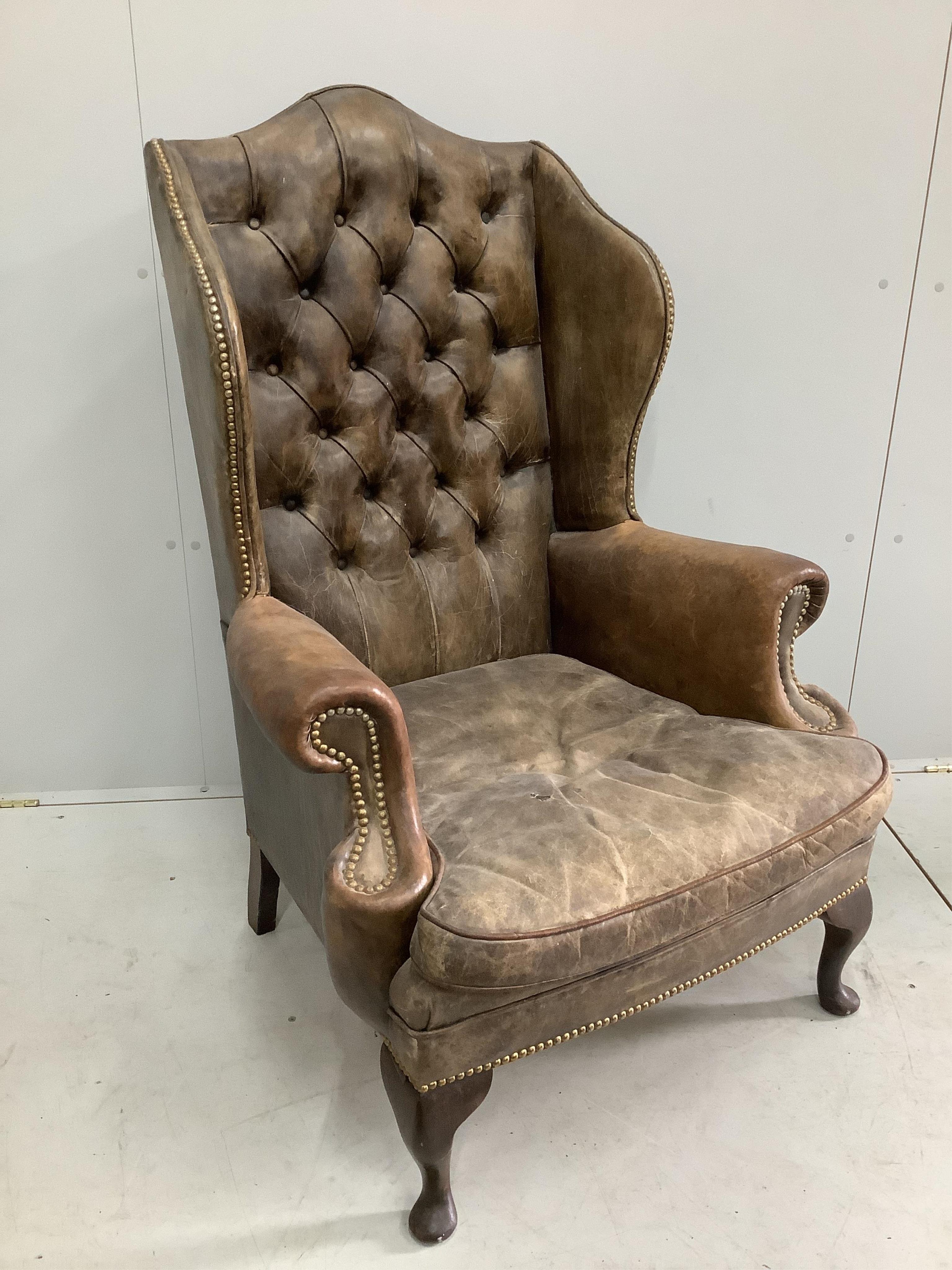 A Victorian style leather button back brown leather wing armchair, width 78cm, depth 70cm, height 114cm